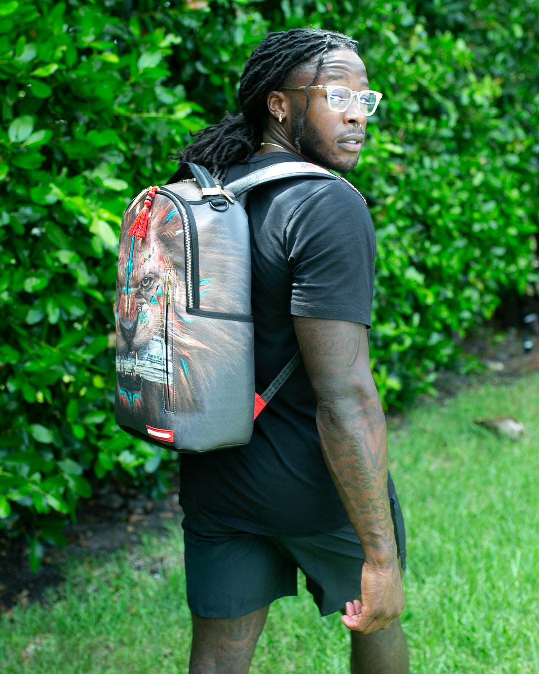 Model wearing clear Sprayground backpack with urban skyline backdrop